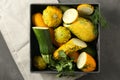 Box with fresh zucchinis on grey table