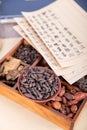 A box full of Chinese herbal medicine and a plate of traditional Chinese medicine xiangfuzi and prescriptions on it Royalty Free Stock Photo