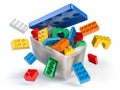 Box full of colorful toy plastic bricks and blocks isolated on white. Delivery children gifts and toys