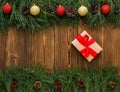 Box with a gift tied with a red ribbon for the holiday to the new year and Christmas, wooden background with fir branches Royalty Free Stock Photo