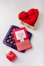 Box of heart shaped chocolates, postcard, red candle, wooden box of fabric hearts on white background. Valentines day 14 February Royalty Free Stock Photo