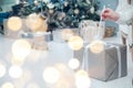 Box with Luxury Metallics gift on background of Christmas tree. Hands open New Year& x27;s gift close-up, copy space.,. Royalty Free Stock Photo