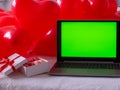 Box with macaron cookies and laptop with chroma key screen on the bed Royalty Free Stock Photo