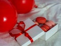 Box with macaron cookies and red baloons on the bed Royalty Free Stock Photo