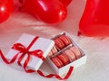 Box with macaron cookies and red baloons on the bed Royalty Free Stock Photo