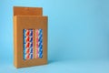 Box with many paper drinking straws on light blue background. Space for text Royalty Free Stock Photo