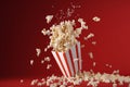 A box of movie popcorn flying out with a red background AI generated Royalty Free Stock Photo