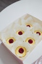 Box of not ready cupcakes. Pastry with jam layer without cream in white paper cover on table, top view. Homemade desserts, making