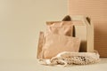 box and paper zip bags in a mesh bag for shopping, beige background top view, mock-up packaging for products Royalty Free Stock Photo