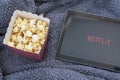 Box of popcorns, netflix and warm soft blanket Royalty Free Stock Photo