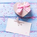 Box with present in form of heart, petals of sakura pink flowers