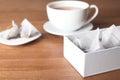 Box with pyramid teabags and cup on table Royalty Free Stock Photo