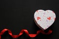 Box of red and pink hearts chocolates on black background with red ribbon, Valentine`s Day, advertising banner Royalty Free Stock Photo