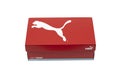 A box of red Puma brand shoes, isolated on a white background.