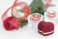 Box with ring, rose and two candles on white background