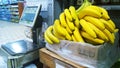 Box with ripe banana near self-service scales in supermarket. Retail industry. Grocery shopping. Discounts on goods. Fruit in