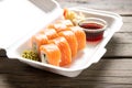 Box with rolls Philadelphia soy sauce and wasabi on a wooden background