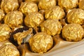 Box of round candies wrapped into golden foil. Royalty Free Stock Photo