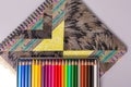 A box with sharpened multi-colored pencils lies on a sketchbook. Royalty Free Stock Photo