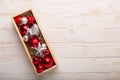 Box with silver red christmas gifts on white wooden background Royalty Free Stock Photo