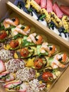 Box with small sandwiches with cold cuts, grilled vegetables, cheese and seafood. Charcuterie boards to order Royalty Free Stock Photo