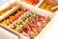 Box with small sandwiches, eclairs, bruschetta with cold cuts, grilled vegetables, cheese and seafood Royalty Free Stock Photo