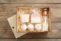 Box with stylish craft gift set on wooden table, flat lay