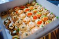 A box of tartlets stuffed with salads and seafood. Catering.