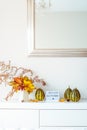 Box with text HELLO AUTUMN, decorative striped pumpkins and vase with bouquet of falling leaves and fern on a white chest, table Royalty Free Stock Photo