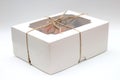 box tied with a rope with a transparent lid with chocolate cupcakes with cream top and crispy topping in paper on a white Royalty Free Stock Photo