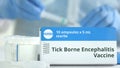 Box with tick-borne encephalitis TBE vaccine on the table against blurred lab assistant. Fictional phaceutical logo