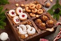 Box with variety of Christmas cookies: linzer cookies with jam, crescents with sugar powder, almond cookies, chocolate cookies