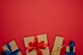 Box wrapped in brown paper and tied with a blue silk ribbon with a bow, gift on a red background Royalty Free Stock Photo