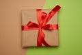 Box wrapped in brown paper and tied with a silk red ribbon with a bow Royalty Free Stock Photo