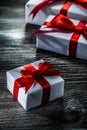 Boxed presents with red bows on wooden board