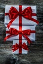 Boxed presents with red knots on wooden board