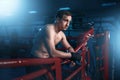 Boxer in black handwraps poses on ring ropes