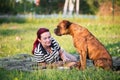 Boxer Dog sitting on a towel in a park with its female owner Royalty Free Stock Photo