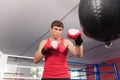 Boxer doing some training on punching bag at gym.