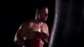 Boxer man during boxing hiting heavy bag at