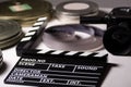 Boxes with the camera films and cinema clapper on the table. Royalty Free Stock Photo