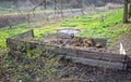 Two large wooden composting boxes of corral in a meadow under trees to store manure leaves and residues from the kitchen Royalty Free Stock Photo