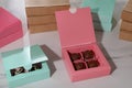 Boxes with delicious candies on white marble table, closeup. Production line