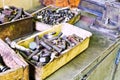 Boxes with old bolts on workbench in turnery