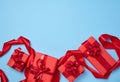 Boxes packed in red paper and tied with ribbon on a blue background Royalty Free Stock Photo