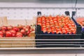 Boxes of red fresh sweet tomatoes in grocery department in shopping center, supermarket, food store. Vegan food, no animal local Royalty Free Stock Photo