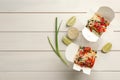 Boxes of vegetarian wok noodles with ingredients on white wooden table, flat lay. Space for text Royalty Free Stock Photo