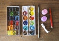 Boxes with watercolors on wooden background