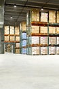 Boxes and wood pallettes on shelves in a warehouse. Royalty Free Stock Photo