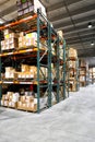 Boxes and wood pallettes on shelves in a warehouse. Royalty Free Stock Photo